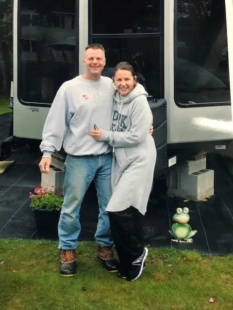 A couple standing next to an RV